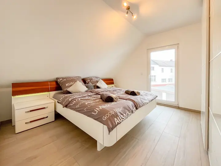 Helles Hauptschlafzimmer mit großem Doppelbett und Nachttischen