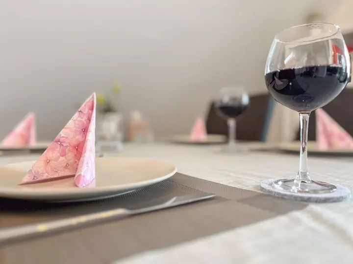 Thoughtfully set dining table with wine glass