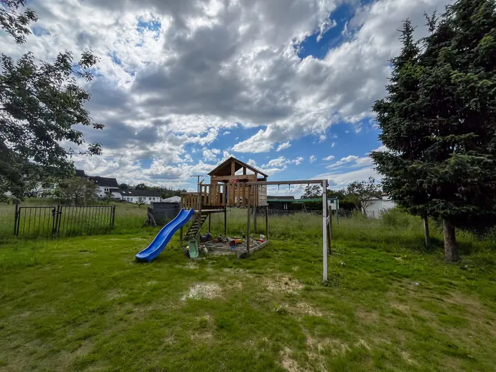 Garden with play tower, slide and swings